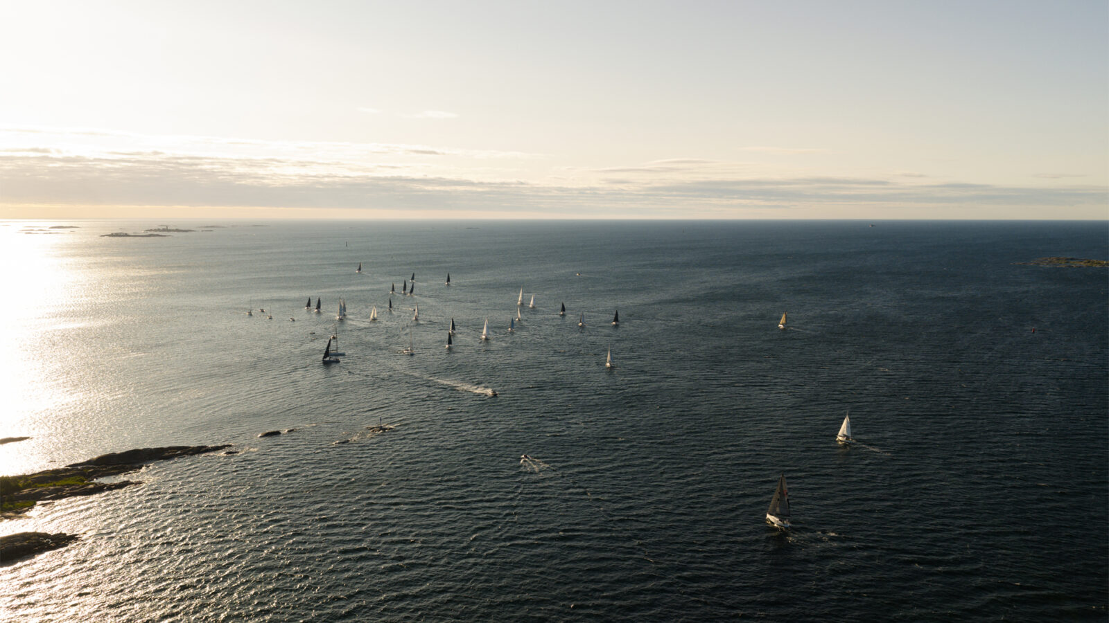 Segelbåtar på öppet hav under solnedgång.